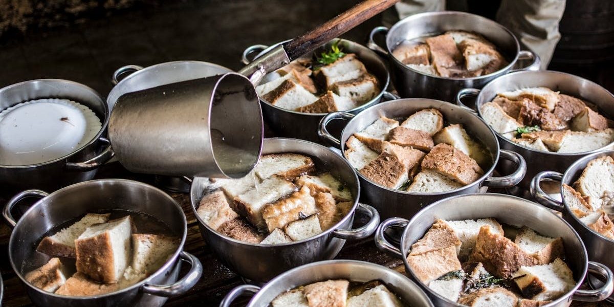A rustic kitchen scene with pots of traditional bread soup being prepared in the Azores.