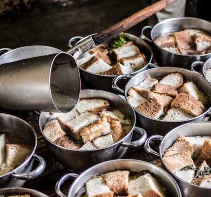 A rustic kitchen scene with pots of traditional bread soup being prepared in the Azores.