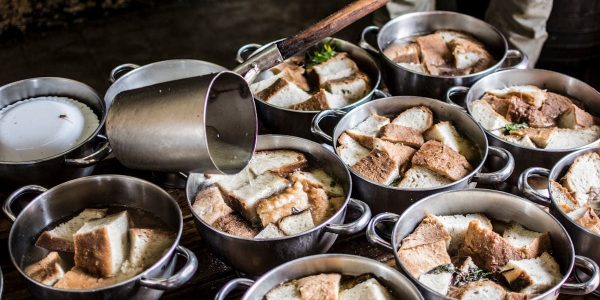 A rustic kitchen scene with pots of traditional bread soup being prepared in the Azores.